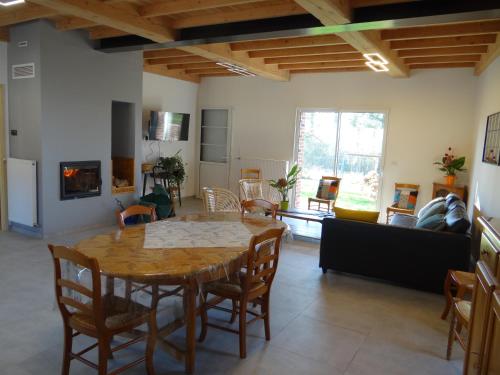 un salon avec une table et des chaises en bois dans l'établissement Gîte au Bonh'Air Indépendant, à Wavrans-sur-lʼAa