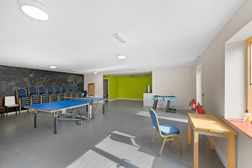 a conference room with tables and chairs and a green wall at Knockree Hostel in Enniskerry