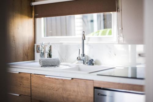 un comptoir de cuisine avec un évier et une fenêtre dans l'établissement Camping les Dunes, au Bois-Plage-en-Ré