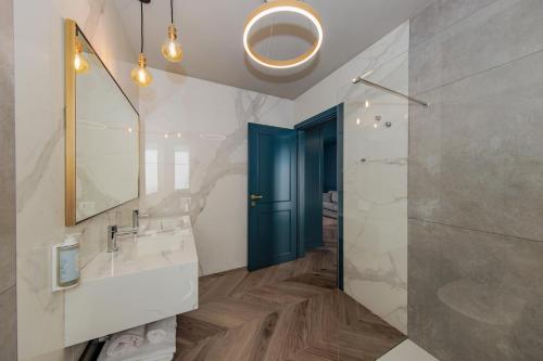 a bathroom with a sink and a blue door at OPHELIA Hotel in Cazzago San Martino