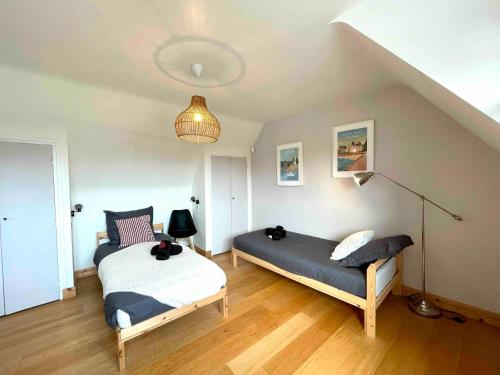 a bedroom with two beds and a lamp at Ty Glou Maison Charmante - 5m plage in Ploemeur