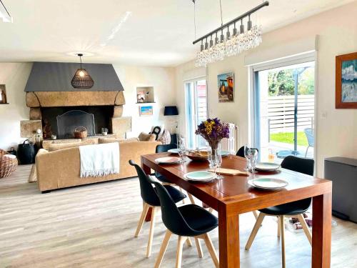 une salle à manger avec une table et un salon avec une cheminée dans l'établissement Ty Glou Maison Charmante - 5m plage, à Ploemeur