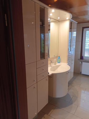 a white bathroom with a sink and a mirror at 3 Zimmer 1OG 100qm Wintergarten Dachterrasse super Badezimmer in Tangstedt