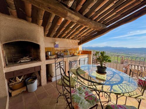 d'une cuisine avec une table et des chaises sur un balcon. dans l'établissement La Maison Bleue, au coeur du village de Callian, à Callian
