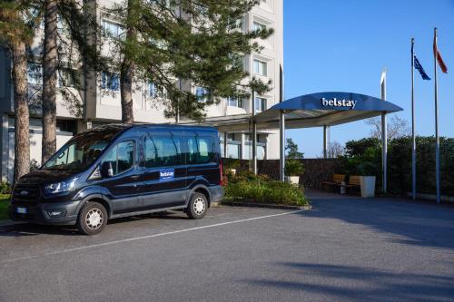 a blue van parked in a parking lot in front of a building at Belstay Milano Assago in Assago