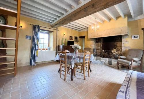 a kitchen with a table and chairs in a room at Le Fournil de Sainte Mère Eglise in Sainte-Mère-Église