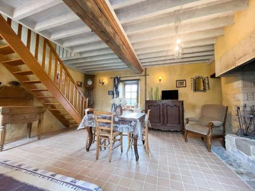a dining room with a table and a staircase at Le Fournil de Sainte Mère Eglise in Sainte-Mère-Église