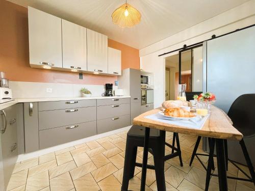 - une cuisine avec une table et un pain dans l'établissement Le Gîte de LiliRose, à Cricqueville-en-Bessin