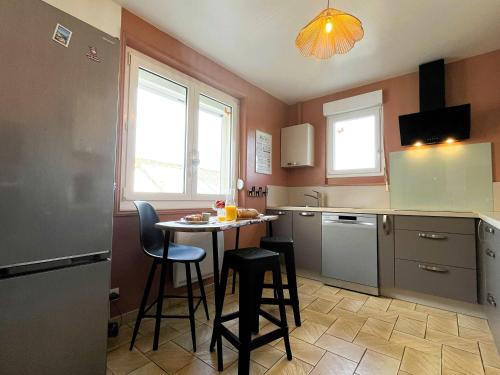 - une cuisine avec une petite table et des chaises dans l'établissement Le Gîte de LiliRose, à Cricqueville-en-Bessin
