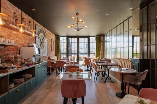 a restaurant with tables and chairs and windows at OPHELIA Hotel in Cazzago San Martino