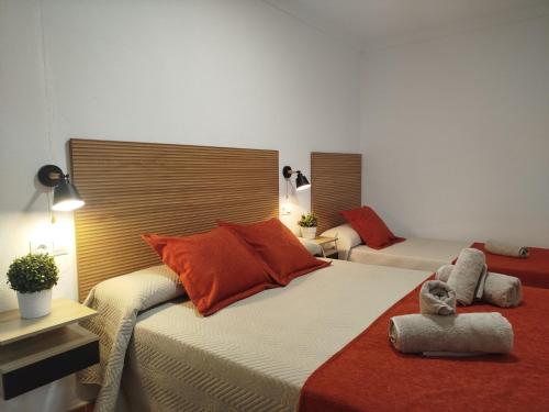 a bedroom with two beds with orange pillows at Casa Lucía - Caminito del rey in Valle de Abdalagís