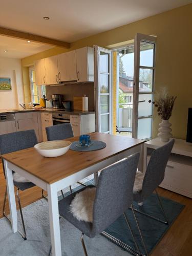 a kitchen with a wooden table with chairs and a table and a table at Villa19hundert5 moderne Ferienwohnungen in zentraler Lage in Lindenberg im Allgäu