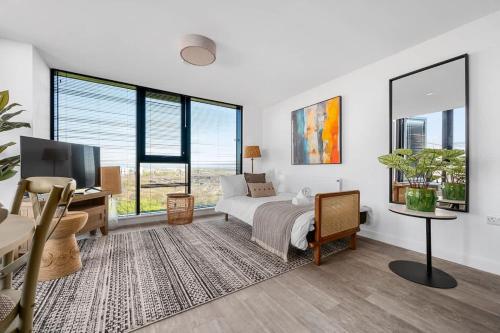 a bedroom with a bed and a desk and windows at Rooftop Flat Stunning City View by City SuperHost in Manchester