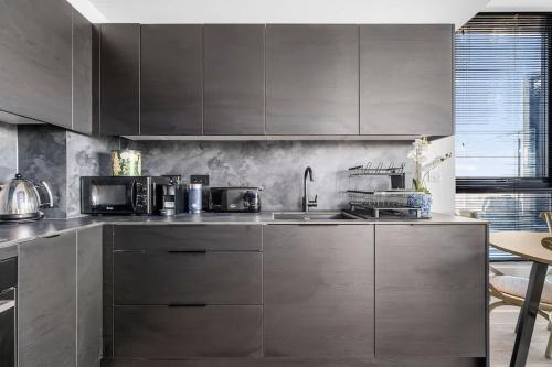 a kitchen with stainless steel cabinets and a sink at Rooftop Flat Stunning City View by City SuperHost in Manchester