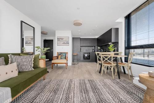 a living room with a green couch and a table at Rooftop Flat Stunning City View by City SuperHost in Manchester