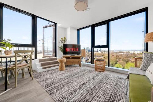 a living room with a tv and large windows at Rooftop Flat Stunning City View by City SuperHost in Manchester