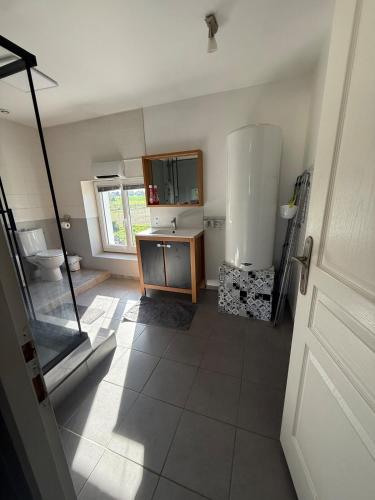 La grande salle de bains est pourvue d'un lavabo et de toilettes. dans l'établissement Nid paisible avec un coin terrasse, à Faramans