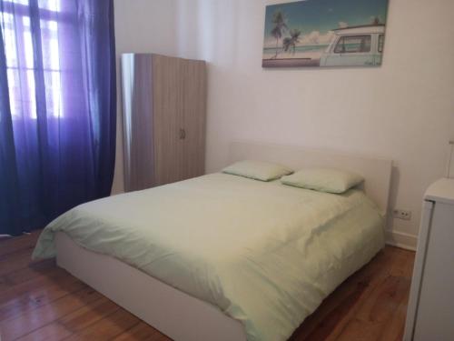 a bedroom with a white bed with two pillows at Lisbon Guesthouse in Lisbon