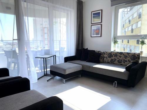 a living room with a couch and a table at Sun Towers - Apartamenty Bryza - Apartamenty z parkingiem in Świnoujście