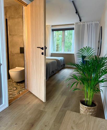 a bedroom with a bed and a door with a plant at Tuba järveäärses puhkemajas - Saarjärve Puhkemaja in Tromsi