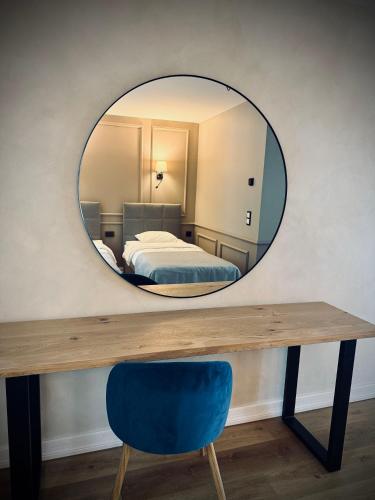 a mirror over a wooden table with a blue chair at Tuba järveäärses puhkemajas - Saarjärve Puhkemaja in Tromsi