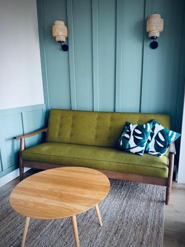a living room with a green couch and a coffee table at Tuba järveäärses puhkemajas - Saarjärve Puhkemaja in Tromsi