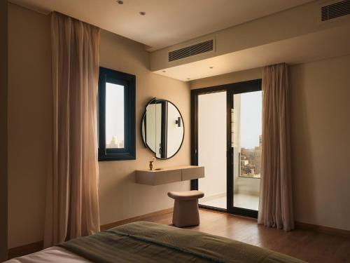 a bedroom with a bed and a mirror and a window at Brassbell Zamalek Diplomatic Zone Near Marriott in Cairo