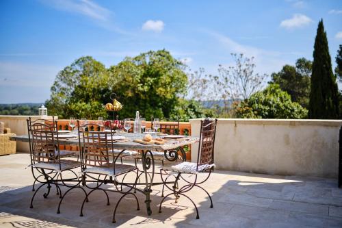 une table et des chaises assises sur une terrasse dans l'établissement Villa Emilienne, à Aigremont