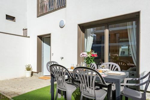 Une table à manger et des chaises sont disponibles sur la terrasse. dans l'établissement Zephyr by Kleidos- Disney 15min! 3 chambres, 2 terrasses, 2 parkings, 2 salles de bain, à Bussy-Saint-Georges