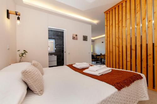 ein Schlafzimmer mit einem weißen Bett mit Handtüchern darauf in der Unterkunft Beco Luz Studio in Luz