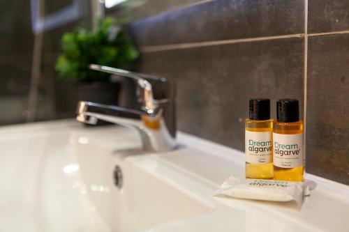 zwei Flaschen ätherischer Öle auf einem Waschbecken in der Unterkunft Beco Luz Studio in Luz