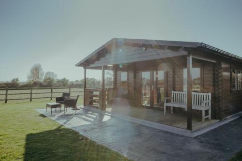 einem hölzernen Pavillon mit zwei Bänken und einem Tisch in der Unterkunft Ty Presto, Parc Y Fronwen in Newborough