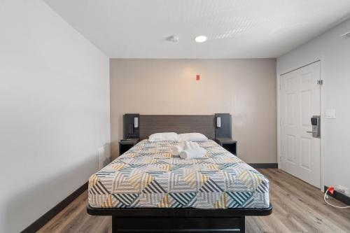 a bedroom with a bed and two night stands at Southern Suites Pensacola Mobile Hwy in Pensacola