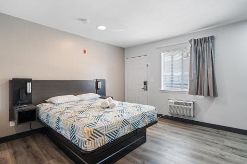 a bedroom with a bed and a window at Southern Suites Pensacola Mobile in Pensacola
