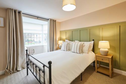 a bedroom with a large bed and a window at Host & Stay - Ginger Bread Cottage in Stokesley