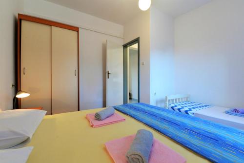 a bedroom with a bed with towels on a table at Slanica Murter MATE in Murter