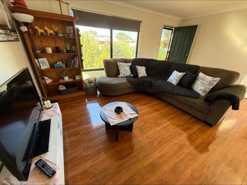 a living room with a couch and a television at C & C Al Mare in Coobowie
