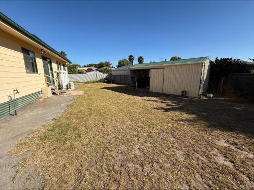 an empty yard next to a house and a building at C & C Al Mare in Coobowie