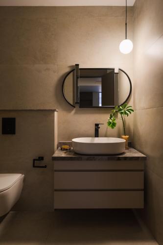 a bathroom with a sink and a mirror at Brassbell Zamalek Diplomatic Zone Near Marriott in Cairo