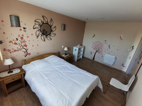 - une chambre avec un lit et des fleurs sur le mur dans l'établissement Appartement T3 Residence calme, à Courthézon