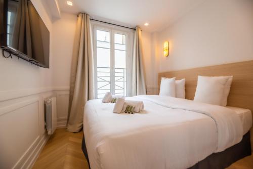 une chambre avec un grand lit blanc avec une fenêtre dans l'établissement Relax in Paris XII, à Paris