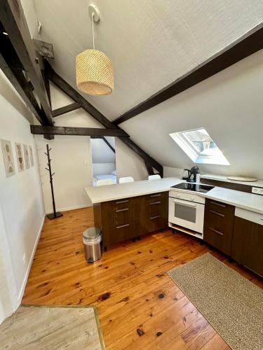 une cuisine mansardée avec parquet et plafond dans l'établissement Le Presbytère, à Charleville-Mézières