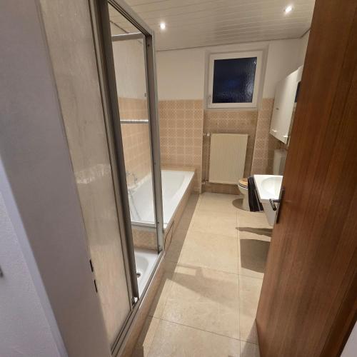 a bathroom with a bath tub and a sink at Ferienwohnungen Sonne in Siegsdorf