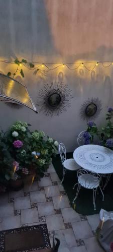 a patio with a table and chairs and flowers at Bienvenue à La Parenthèse in Follainville-Dennemont