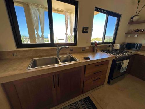 a kitchen with a sink and two windows at Casa Corazon - Private Home w Mtn & Ocean Views! in El Pescadero