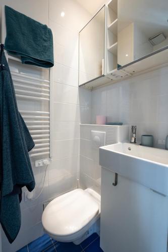 une salle de bain blanche avec des toilettes et un lavabo dans l'établissement Cosy Studio - 5mn to Paris, à Bagnolet
