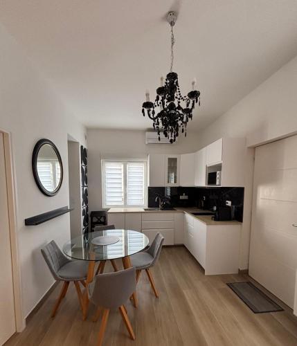 une salle à manger avec une table et des chaises en verre dans l'établissement Ravissant T2, proche centre, quartier très calme,,parking,clim, déco soignée, à Montpellier