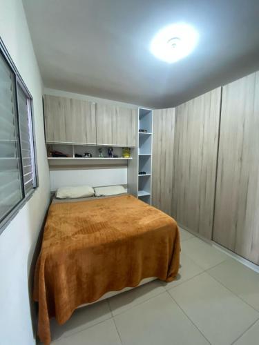 a bedroom with a bed with a brown blanket at Casa privada 3 quartos ótima localização in Piranhas