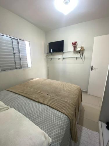 a white bedroom with two beds and a window at Casa privada 3 quartos ótima localização in Piranhas