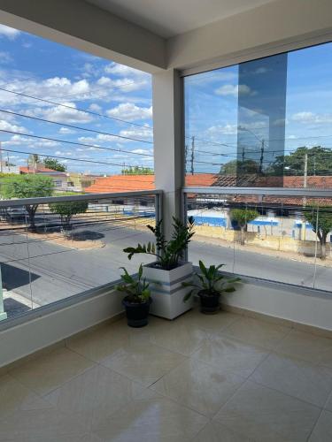 a room with a large window with potted plants at Casa privada 3 quartos ótima localização in Piranhas